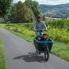 Man met kinderen in elektrische bakfiets van CUBE